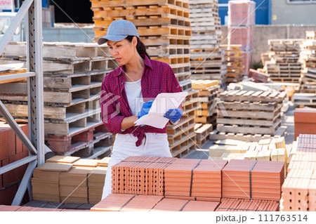 Asian female worker keeps records of ceramic tiles 111763514