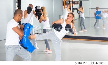 Active hispanic woman working with trainer 111764045