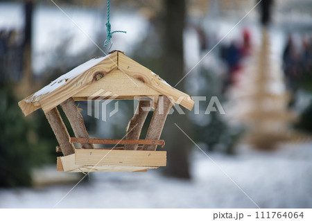 Bird feeder hanging from a string in snowy environment Bird feeder hanging from a string in snowy environment 111764064