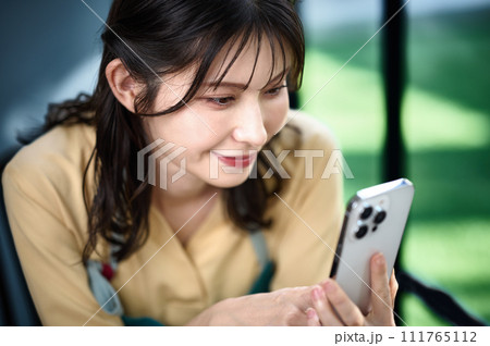 部屋でスマホを操作する主婦 部屋でスマホを操作する主婦 111765112