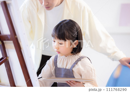 絵画教室 先生の指導を受けながらキャンパスに絵を描く女の子 絵画教室 先生の指導を受けながらキャンパスに絵を描く女の子 111768290