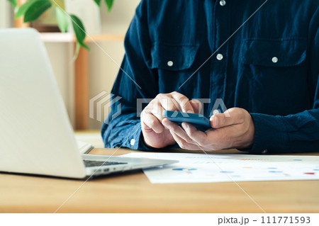 パソコンとスマホを操作する男性の手元 111771593