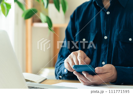 パソコンとスマホを操作する男性の手元 111771595