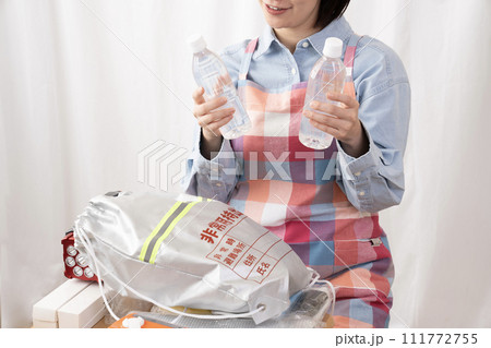 非常持ち出し袋の中身を確認する女性の手元 111772755