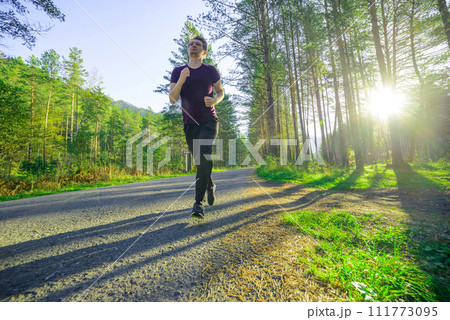 Man jogging in city partk at beautiful summer day. Sport fitness model caucasian ethnicity training outdoor. Man jogging in city partk at beautiful summer day. Sport fitness model caucasian ethnicity training outdoor. 111773095