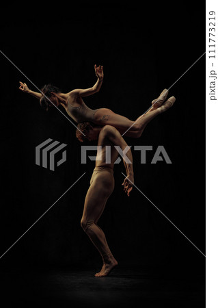 Artistic, talented and passionate ballet dancers, man and woman making fascinating performance against black background. Weightlessness 111773219