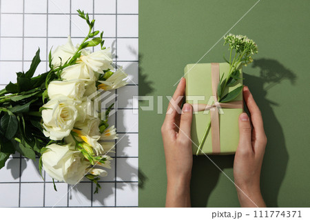 A gift with flowers on a green background. 111774371
