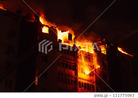 Pieces of the house fall due to the fire. Fire blazing in apartment house. Pieces of the house fall due to the fire. Fire blazing in apartment house. 111775063