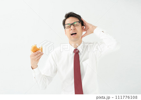 ハンバーガーを食べるビジネスマン ハンバーガーを食べるビジネスマン 111776108