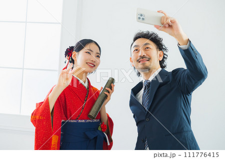 袴の女性の写真を撮る男性 袴の女性の写真を撮る男性 111776415