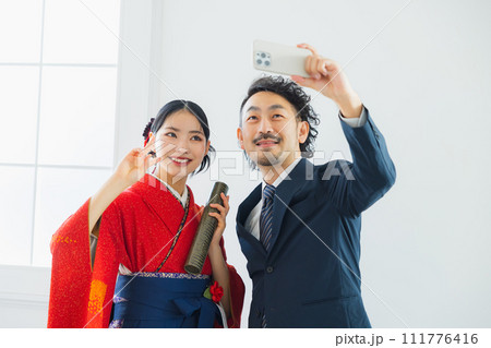 袴の女性の写真を撮る男性 111776416