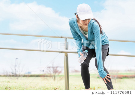公園で運動中にふくらはぎが痛くなるアジア人女性 公園で運動中にふくらはぎが痛くなるアジア人女性 111776691
