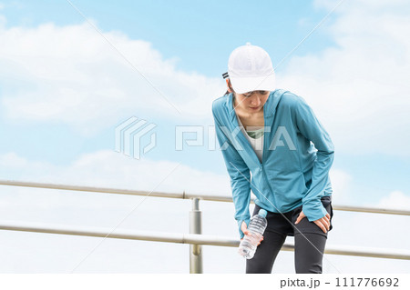 ランニング・ウォーキング中に太ももが痛くなるアジア人女性 ランニング・ウォーキング中に太ももが痛くなるアジア人女性 111776692