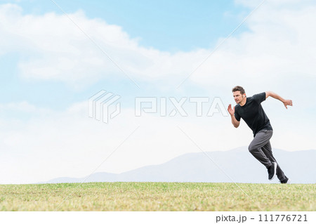 トレーニングのため公園でダッシュで走る練習をするスポーツウェアを着たアスリートの白人男性 111776721