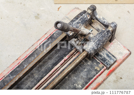 Cutting tiles tool tile cutter closeup Cutting tiles tool tile cutter closeup 111776787