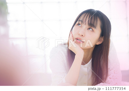 恋愛や恋のイメージ 頬杖をつく女性のクローズアップ 恋愛や恋のイメージ 頬杖をつく女性のクローズアップ 111777354