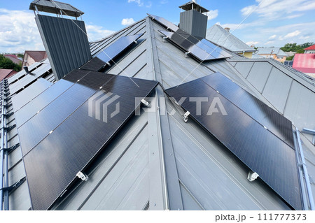 House with solar panels on rooftop for generating electricity through photovoltaic effect. Home with solar power system on roof. Concept of alternative energy, autonomy, power sustainable resources. 111777373