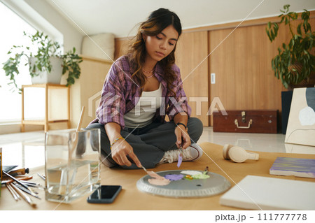 Creative teen girl mixing paints on palette Creative teen girl mixing paints on palette 111777778