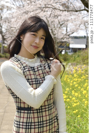 サクラ咲く公園でポーズをとる若くスリムな女性 サクラ咲く公園でポーズをとる若くスリムな女性 111778477