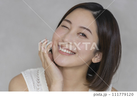 カメラ目線でウインクをする20代の女性　ビューティーイメージ　ポートレート 111779120