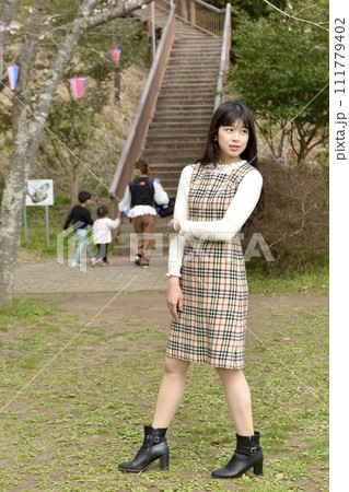 サクラ咲く公園でポーズをとる若くスリムな女性 サクラ咲く公園でポーズをとる若くスリムな女性 111779402