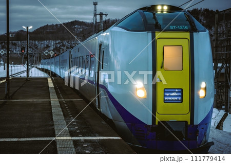 夕暮れにホームに滑り込む列車 111779414