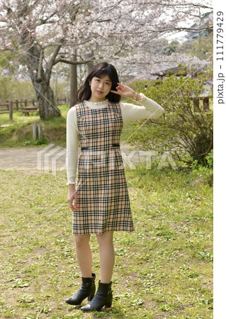 サクラ咲く公園でポーズをとる若くスリムな女性 サクラ咲く公園でポーズをとる若くスリムな女性 111779429