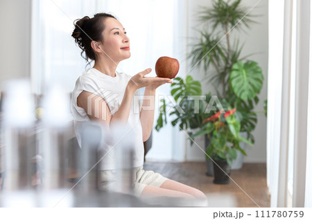 リンゴを手に持つ女性　ビューティーイメージ 111780759