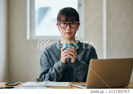 両手でコーヒーカップを持ちぼーっとする若い女性 両手でコーヒーカップを持ちぼーっとする若い女性 111780767