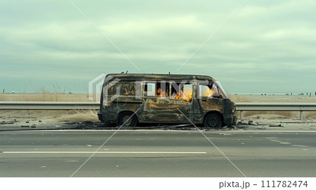 Burnt out big van next to the road. The car after the accident. A burnt-out car without windows and tires Burnt out big van next to the road. The car after the accident. A burnt-out car without windows and tires 111782474