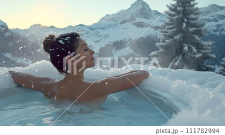 Woman relaxing in hot bath outdoors, sitting back and enjoying beautiful view on snowy mountains. Winter holidays in the mountains, hot water treatments concept 111782994
