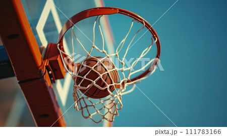 Basketball ball entered in the basket touching the net. Playing in the street on outdoor court, close up 111783166