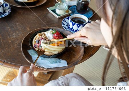 パンケーキを食べる女性 111784068