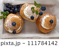 Top View of three Semla Cakes on wooden box with berries. semla top view from above 111784142