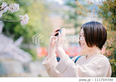 春の京都観光で桜を見る若い女性 111784390