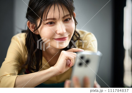 部屋でスマホを操作する主婦 部屋でスマホを操作する主婦 111784837