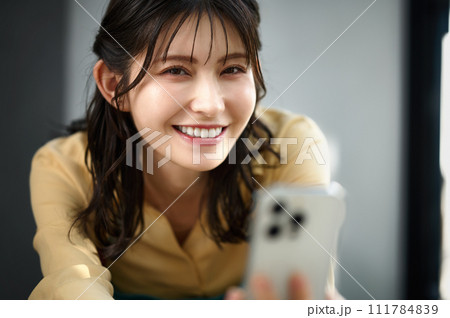 部屋でスマホを操作する主婦 部屋でスマホを操作する主婦 111784839