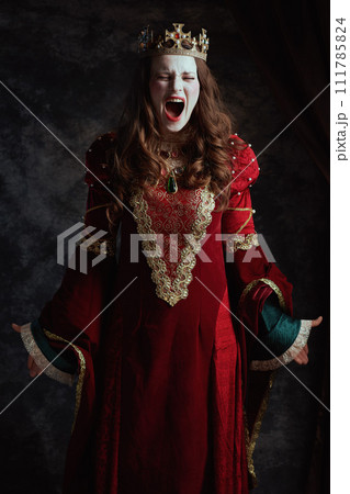 furious medieval queen in red dress with white makeup 111785824