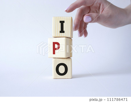 IPO- Initial Public Offering symbol. Concept word IPO on wooden cubes. Businessman hand. Beautiful white background. Business and IPO concept. Copy space. IPO- Initial Public Offering symbol. Concept word IPO on wooden cubes. Businessman hand. Beautiful white background. Business and IPO concept. Copy space. 111786471