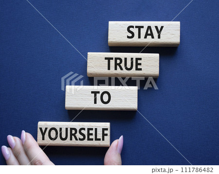 Stay True to Yourself symbol. Wooden blocks with words Stay True to Yourself. Businessman hand. Beautiful deep blue background. Business and Stay True to Yourself concept. Copy space. 111786482