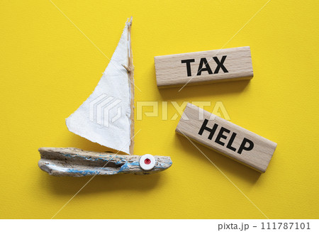 Tax Help symbol. Concept word Tax Help on wooden blocks. Beautiful yellow background with boat. Business and Tax Help concept. Copy space 111787101