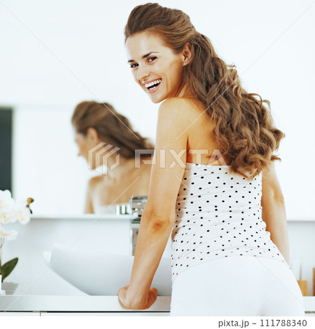 smiling young woman in bathroom smiling young woman in bathroom 111788340