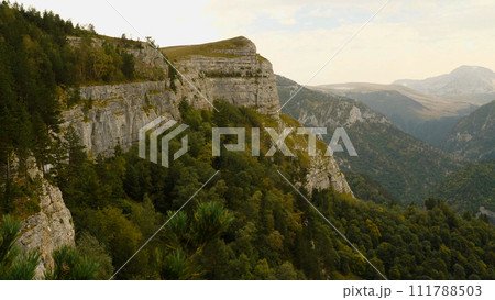 Beautiful view of a steep cliff and gorge. Pine trees grow at the foot of the cliff. Mountains and cliffs in the national park. Hiking in the mountains in the wilderness. Beautiful view of a steep cliff and gorge. Pine trees grow at the foot of the cliff. Mountains and cliffs in the national park. Hiking in the mountains in the wilderness. 111788503