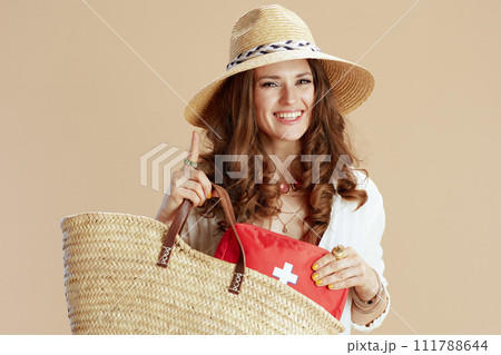 happy trendy woman in blouse and shorts on beige 111788644