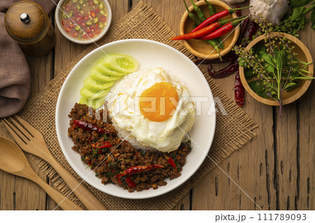Thai Basil Minced beef,Stir fired ground beef with garlic and basil leaf in chilli sauce with Cooked rice topped with fried egg (Pad Kra pao).Top view Thai Basil Minced beef,Stir fired ground beef with garlic and basil leaf in chilli sauce with Cooked rice topped with fried egg (Pad Kra pao).Top view 111789093