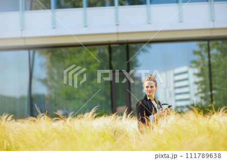 pensive woman employee in business district using smartphone 111789638
