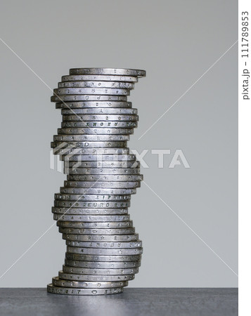 Unstable coins stack of two euro coins on a grey background, future balance concept 111789853