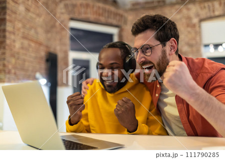 Two colleagues working together and looking excited 111790285