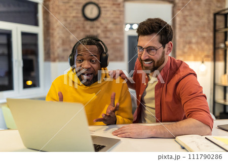 Two colleagues working together and looking excited 111790286