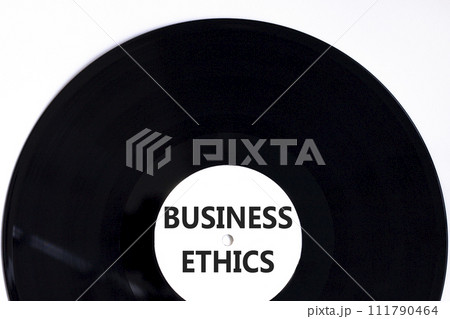 Business ethics symbol. Concept words Business ethics on beautiful black vinyl disk. Beautiful white table white background. Business ethics concept. Copy space. Business ethics symbol. Concept words Business ethics on beautiful black vinyl disk. Beautiful white table white background. Business ethics concept. Copy space. 111790464